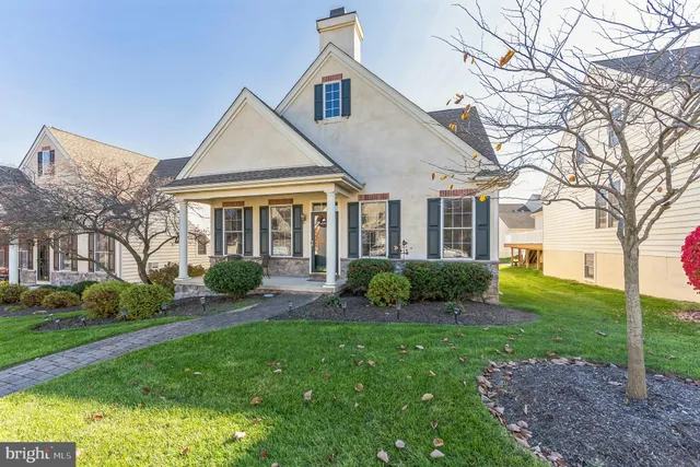 a front view of a house with a yard and potted plants