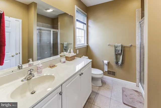 a bathroom with a double vanity sink toilet and mirror