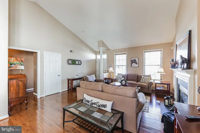 a living room with furniture a fireplace and wooden floor