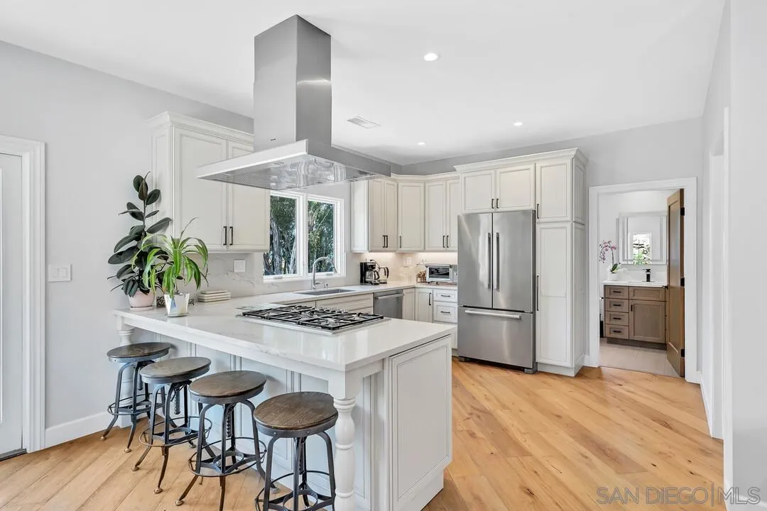 1356 Real Way Lane Alpine, CA 91901 - Photo 12 of 58 a kitchen with a refrigerator a stove a sink and a dining table with wooden floor