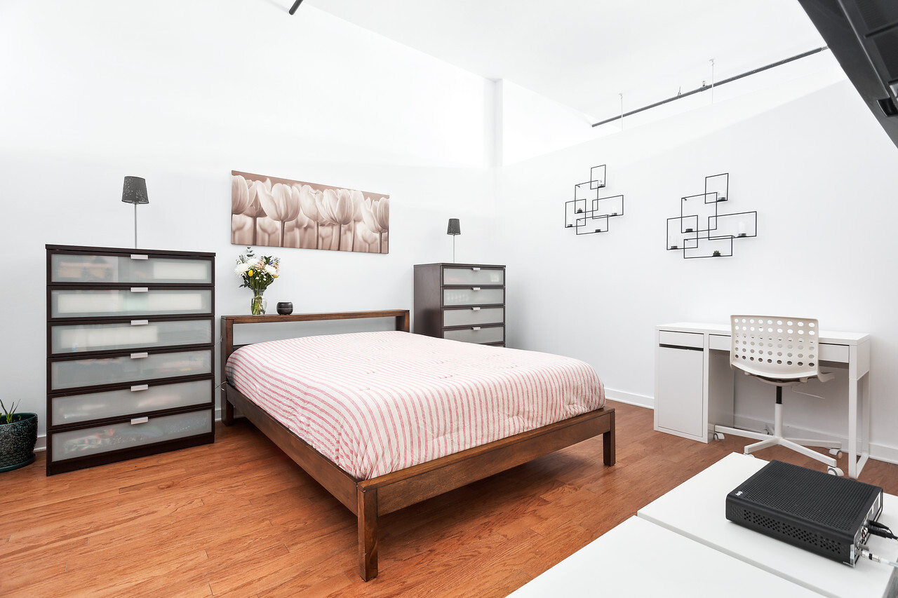 1224 West Van Buren Street, Unit 822 Chicago, IL 60607 - Photo 11 of 21 a bedroom with a bed and dresser