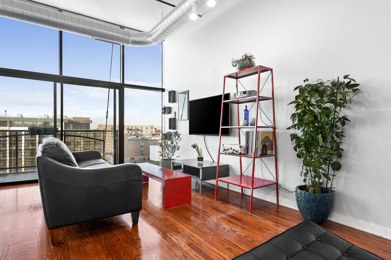 1224 West Van Buren Street, Unit 822 Chicago, IL 60607 - Photo 3 of 21 a living room with furniture potted plant and a flat screen tv