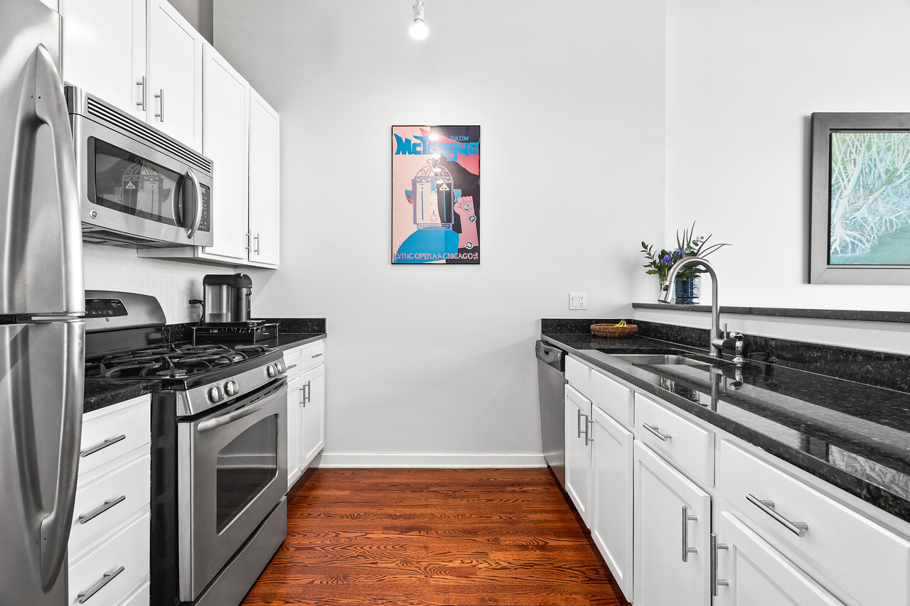 1224 West Van Buren Street, Unit 822 Chicago, IL 60607 - Photo 9 of 21 a kitchen with stainless steel appliances granite countertop a stove and a microwave
