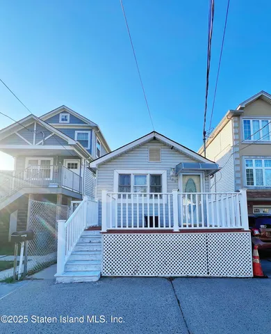a front view of a house with a yard and deck