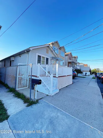 a view of a house with a patio and a yard