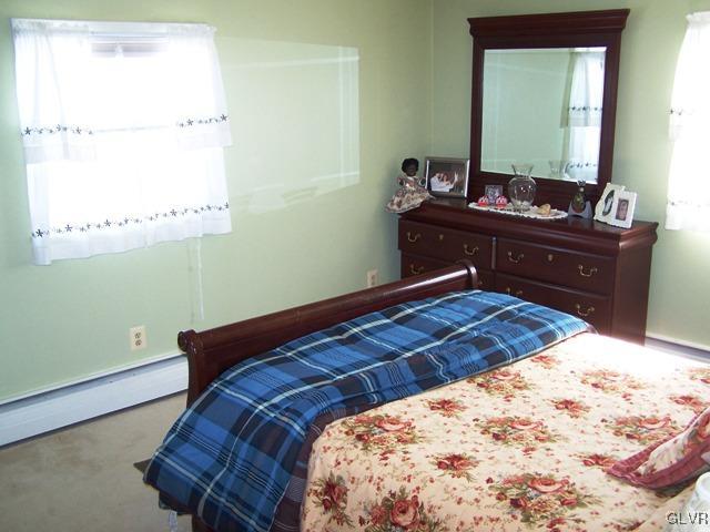 496 Covered Bridge Road, Unit 1 Quakertown, PA 18951 - Photo 8 of 11 a bedroom with a bed and a mirror on the dresser