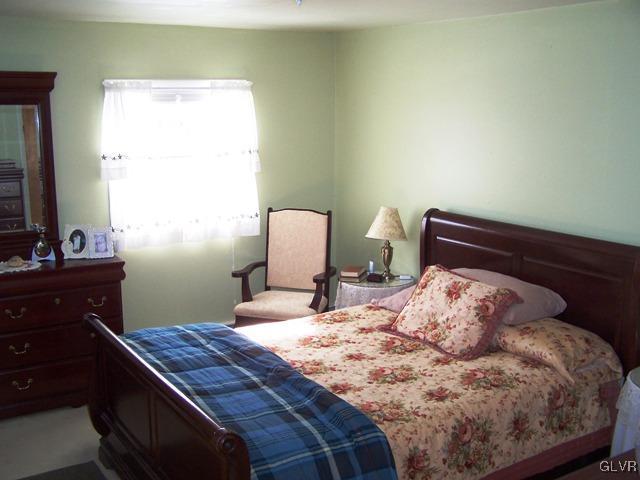 496 Covered Bridge Road, Unit 1 Quakertown, PA 18951 - Photo 9 of 11 a bedroom with a bed and a dresser in it