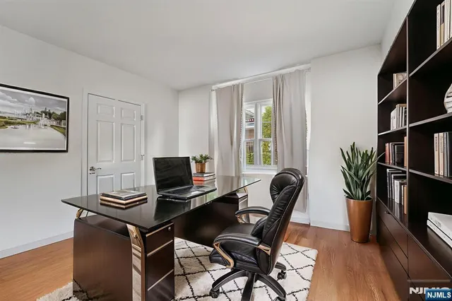 a view of a workspace with furniture and a window
