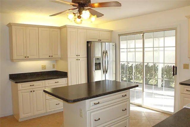 a kitchen with granite countertop a stove a sink and a refrigerator