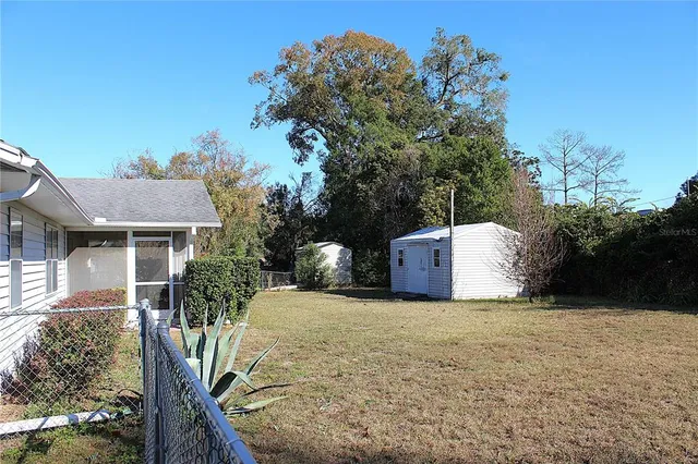 a view of a house with a yard and large tree
