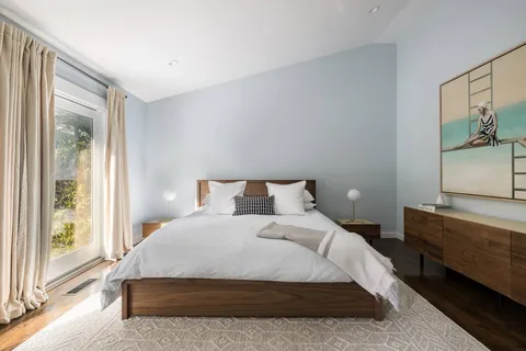 a large bed sitting in a bedroom next to a window