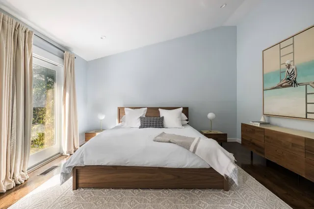 a large bed sitting in a bedroom next to a window