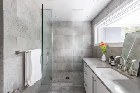 a bathroom with a granite countertop sink a shower and a mirror
