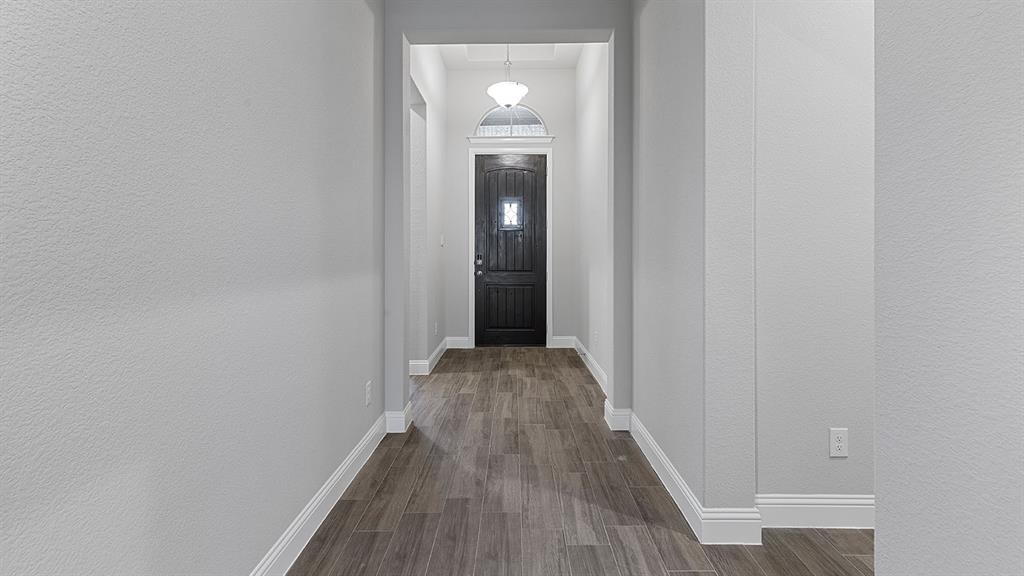 11312 Treehouse Trail Justin, TX 76247 - Photo 26 of 31 a view of a hallway with wooden floor and staircase