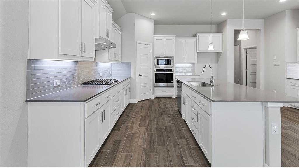 11312 Treehouse Trail Justin, TX 76247 - Photo 1 of 31 a kitchen with stainless steel appliances a sink stove refrigerator and cabinets