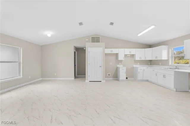 a view of a kitchen with white cabinets and wooden floor