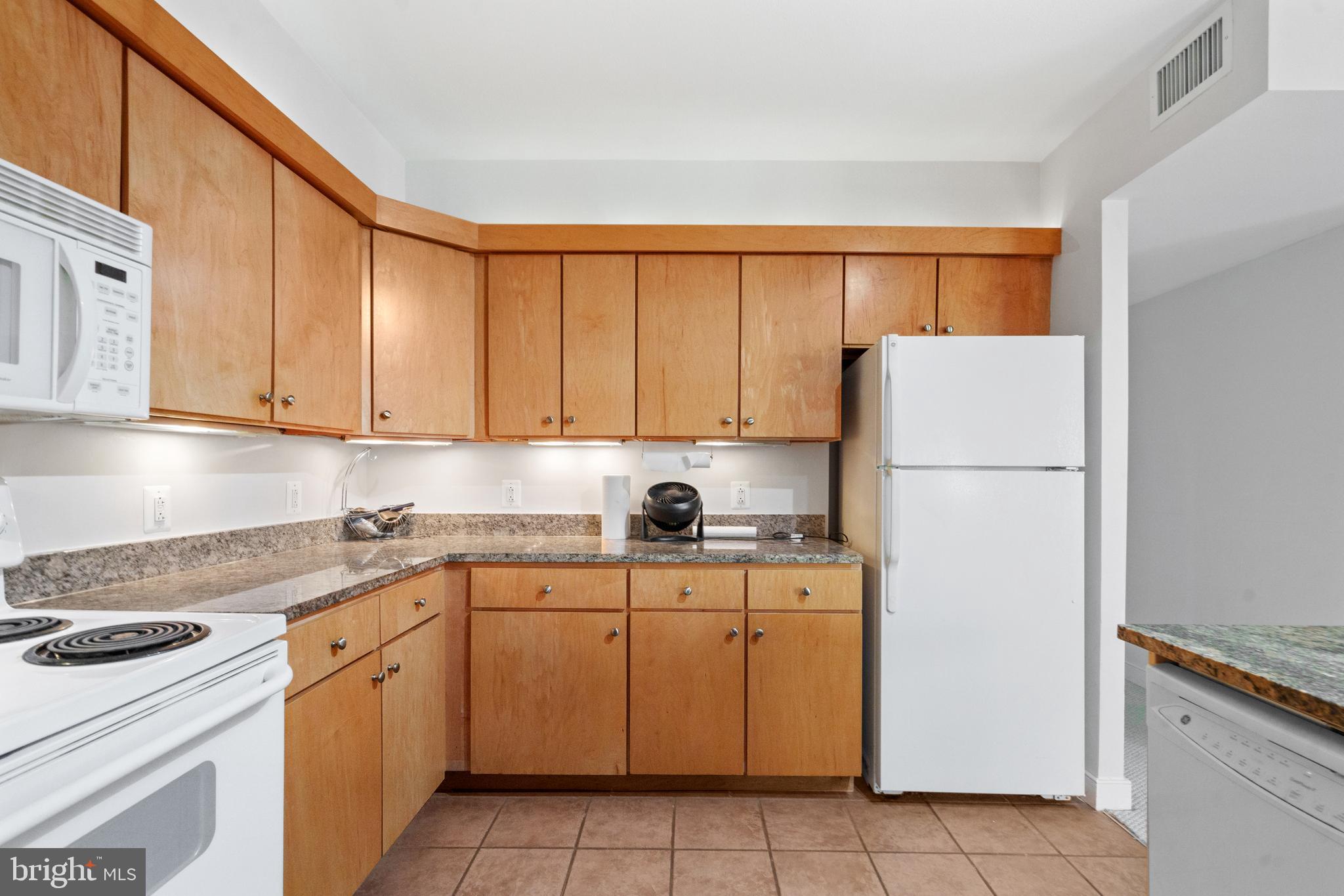 616 E Street Northwest, Unit 304 Washington, DC 20004 - Photo 22 of 53 a kitchen with a sink a refrigerator and white cabinets