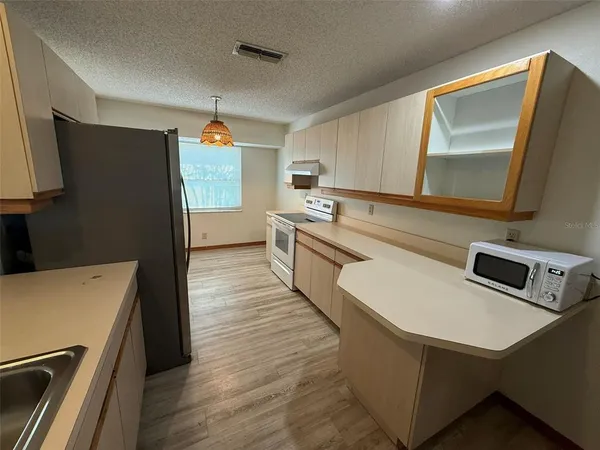 a kitchen with stainless steel appliances a refrigerator sink and microwave