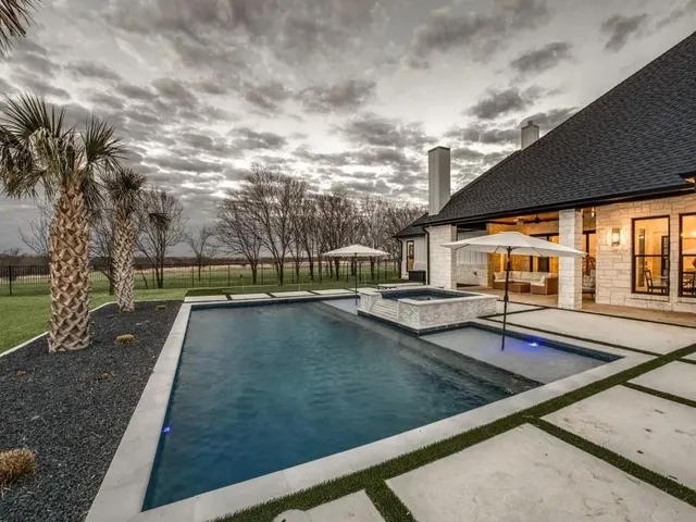 a view of pool with umbrella and table
