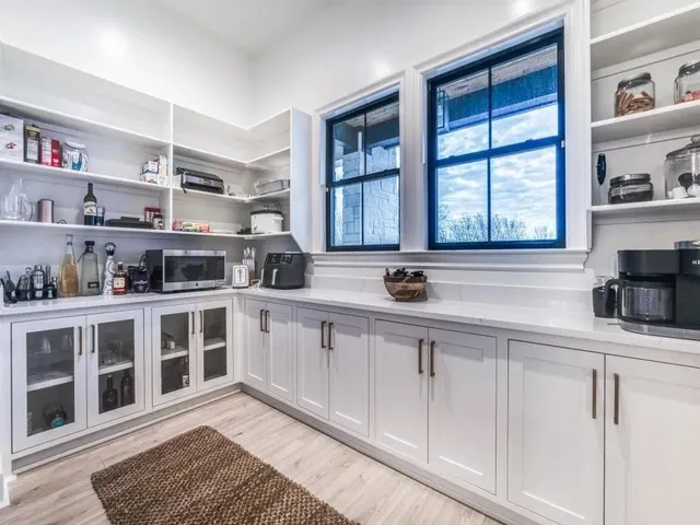 a white kitchen with granite top and stainless steel appliances