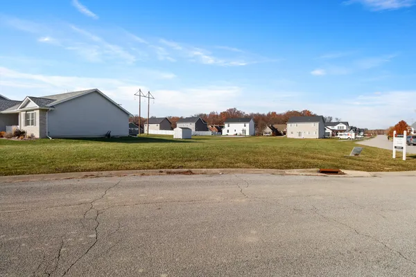 a view of a house with a yard and a large tree