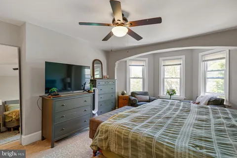 a bedroom with a large bed and a flat tv screen on dresser
