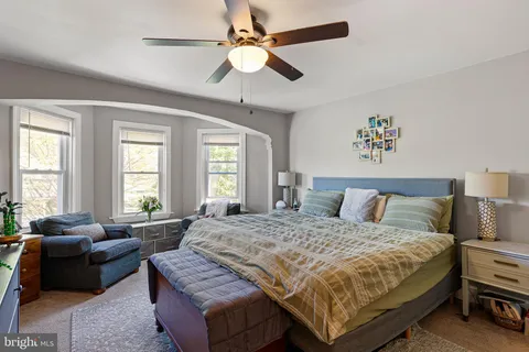a bedroom with a bed couch and window