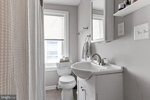 a bathroom with a sink a toilet and a mirror