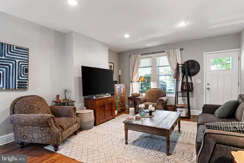 a living room with furniture a flat screen tv and a window
