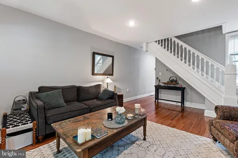 a living room with furniture and a wooden floor