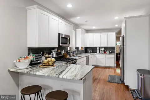 a kitchen with a sink a stove a refrigerator and cabinets