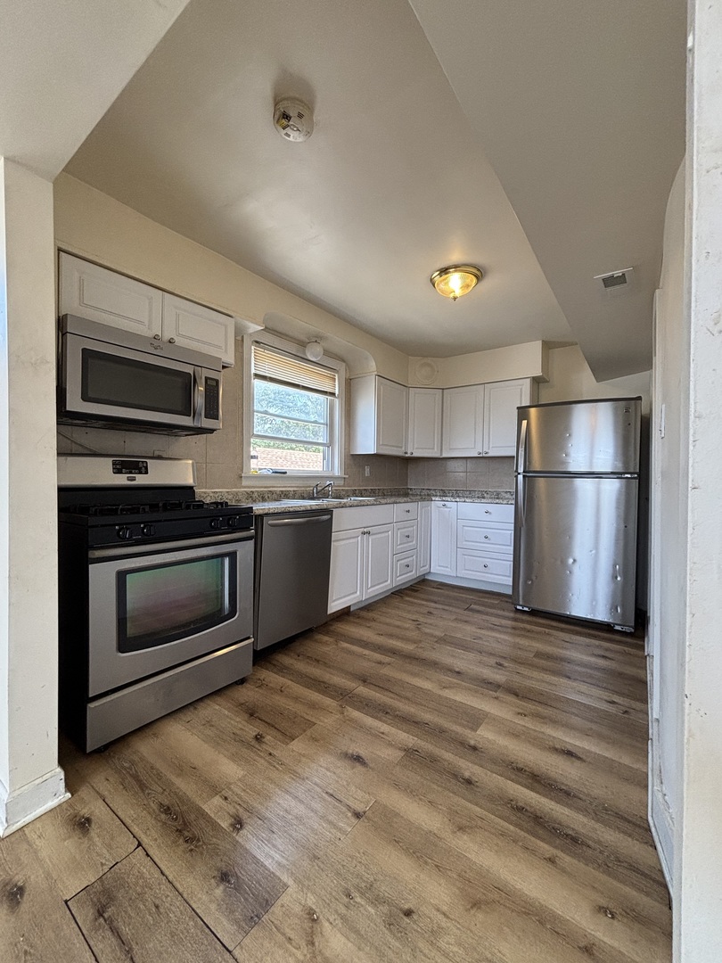 2530 North Neva Avenue Chicago, IL 60707 - Photo 15 of 50 a kitchen with a refrigerator and a stove top oven