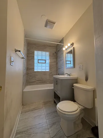 a bathroom with a toilet a sink a mirror and a bathtub