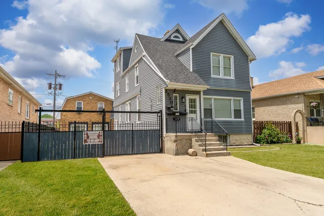 a view of a house with wooden fence and a yard