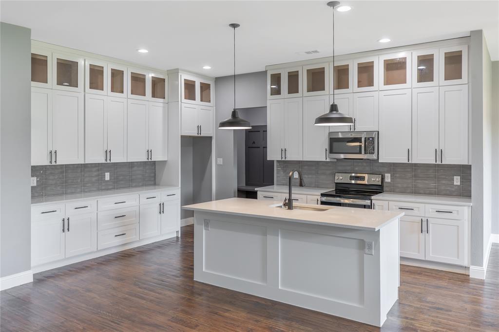 10560 Lago Vista Quinlan, TX 75474 - Photo 4 of 31 a kitchen with stainless steel appliances granite countertop a stove a sink dishwasher a refrigerator and white cabinets with wooden floor