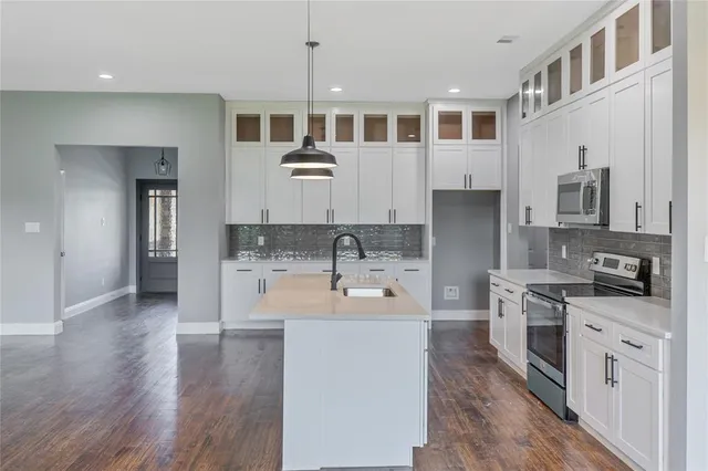 a large kitchen with stainless steel appliances granite countertop a stove and a sink