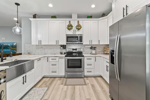 a kitchen with a refrigerator and white cabinets