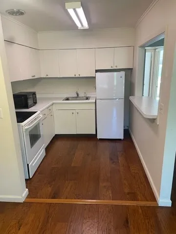 a kitchen with white cabinets and white appliances