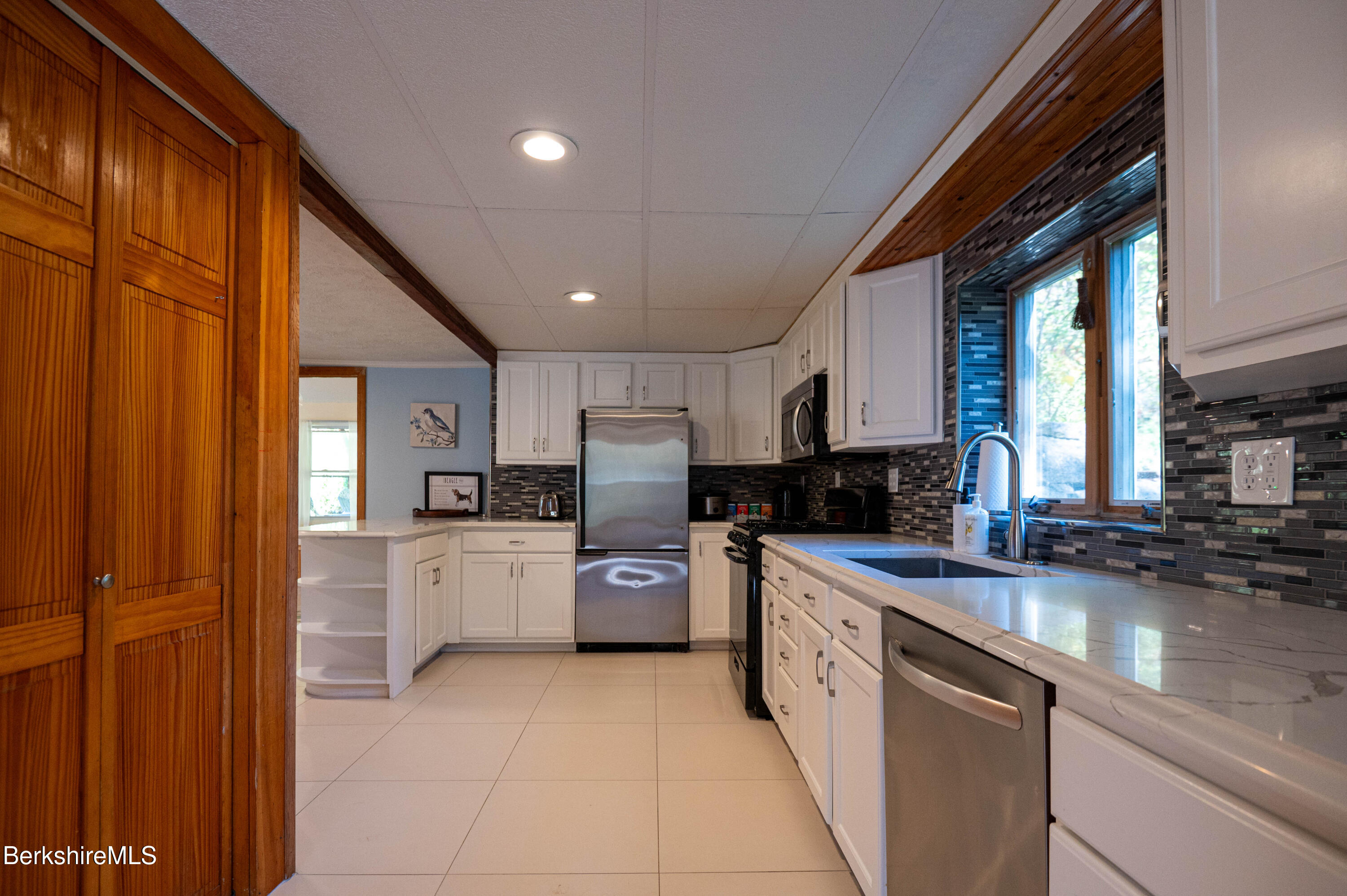 1600 Pleasant Street Lee, MA 01260 - Photo 14 of 26 a kitchen with a sink a counter top space stainless steel appliances a counter space and cabinets