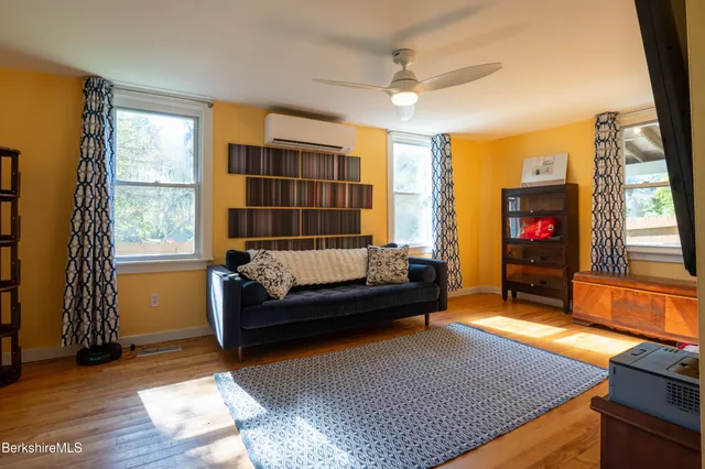 a view of a hallway with wooden floor and a living room