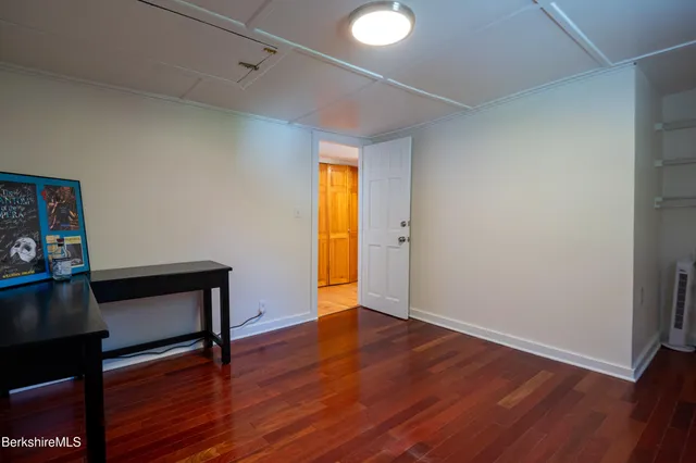 a view of an empty room with wooden floor