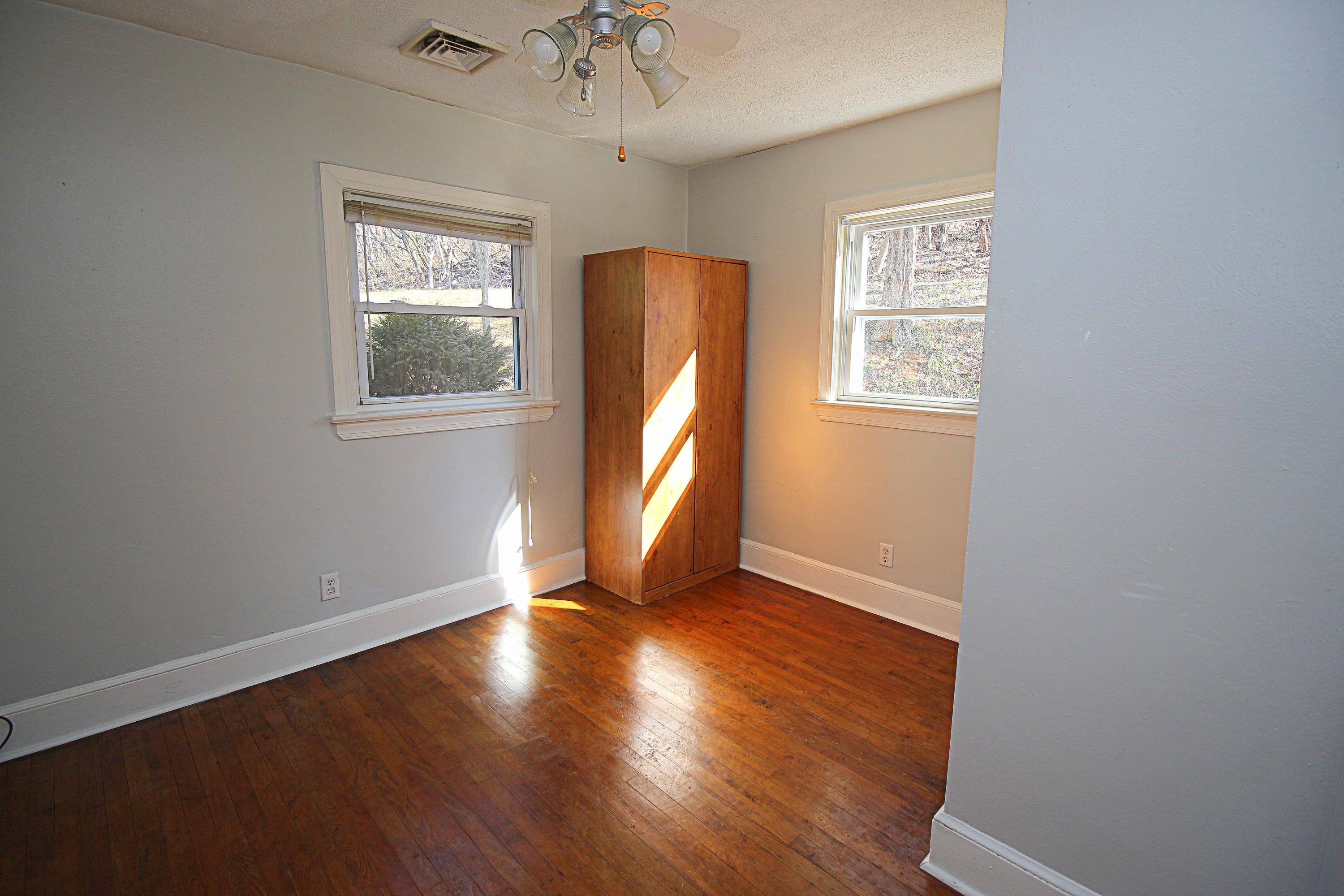 71 Rabbits Way Blue Ridge, VA 24064 - Photo 10 of 23 an empty room with wooden floor chandelier and windows