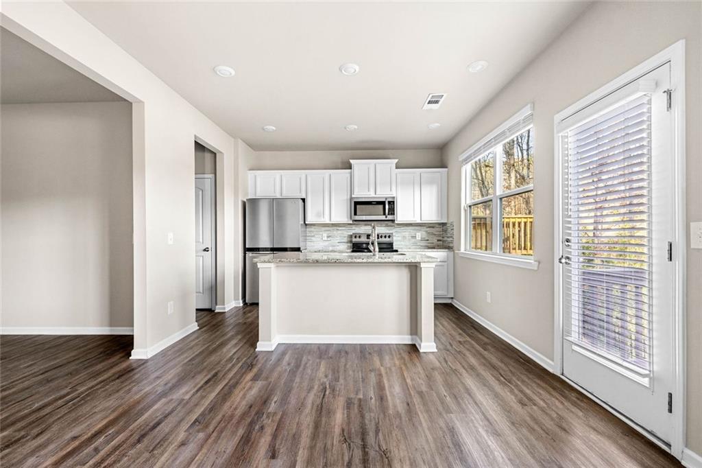 217 Whitetail Circle Canton, GA 30115 - Photo 14 of 30 a white kitchen with wooden floor and electronic appliances