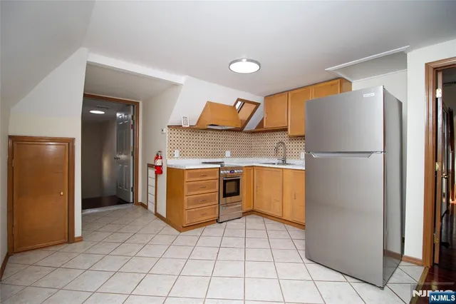 a kitchen with stainless steel appliances granite countertop a refrigerator and a stove
