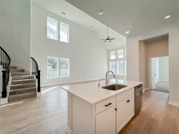a view of a hallway with stairs and wooden floor
