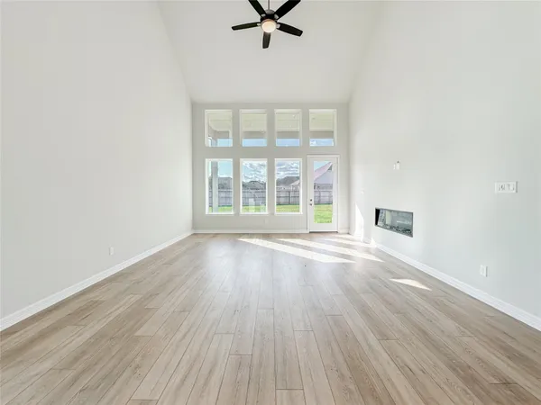 a view of a livingroom with wooden floor and a ceiling fan