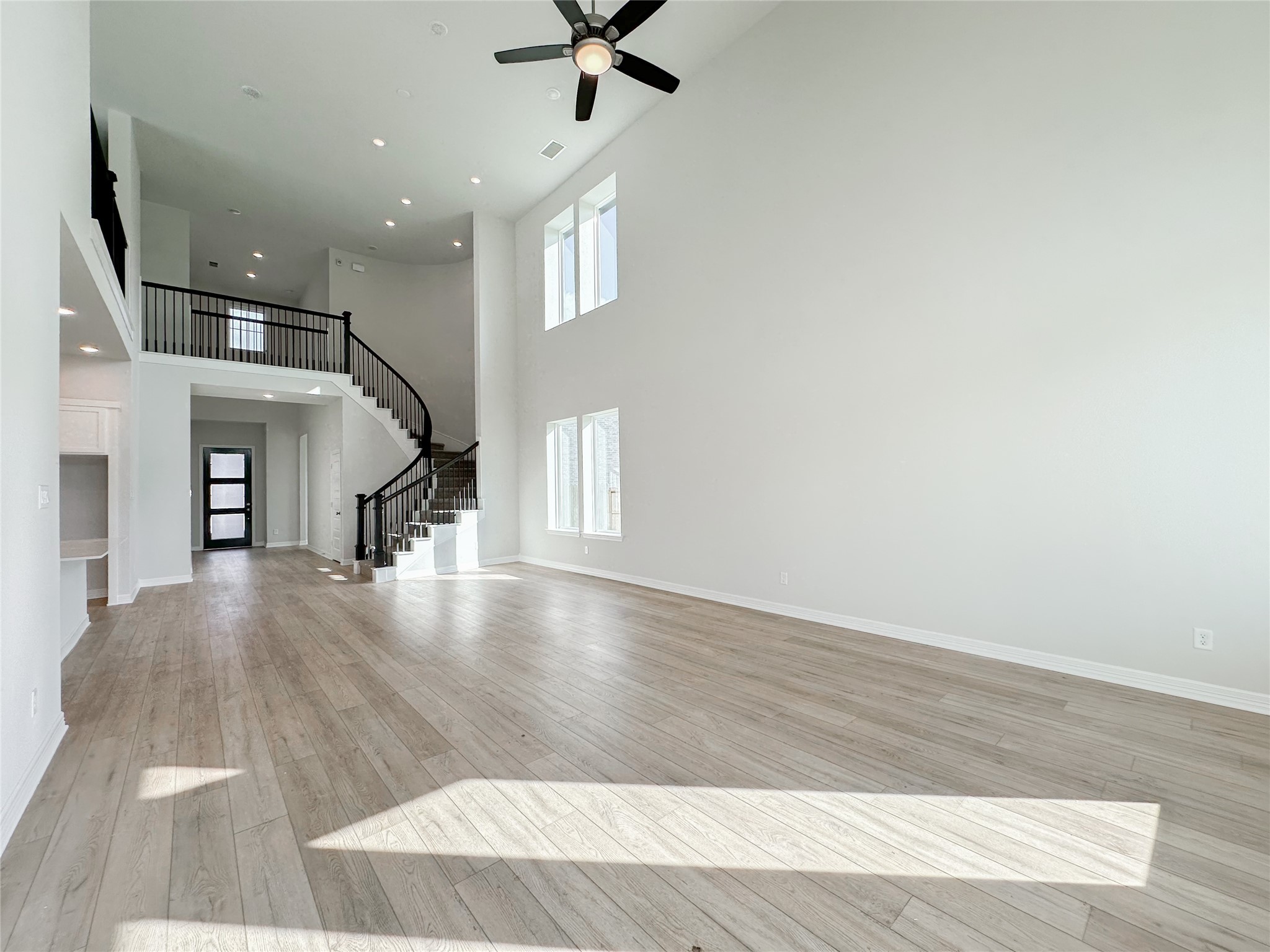 9411 Coleraine Court Tomball, TX 77375 - Photo 17 of 34 a view of a livingroom with wooden floor and a ceiling fan