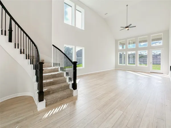 a large kitchen with kitchen island a sink a stove a refrigerator and white cabinets