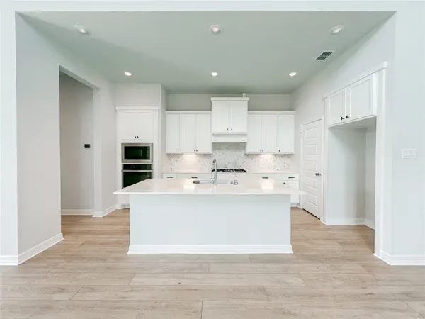 a kitchen with a sink and wooden floor