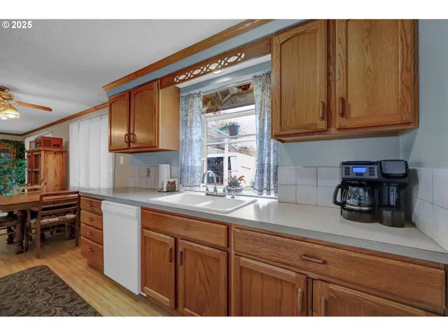a kitchen with kitchen island granite countertop a sink cabinets and wooden floor